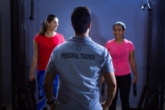 Personal trainer orientando alunas durante treino em grupo